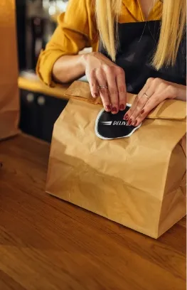 Takeaway Tüte wird auf einer Theke geschlossen